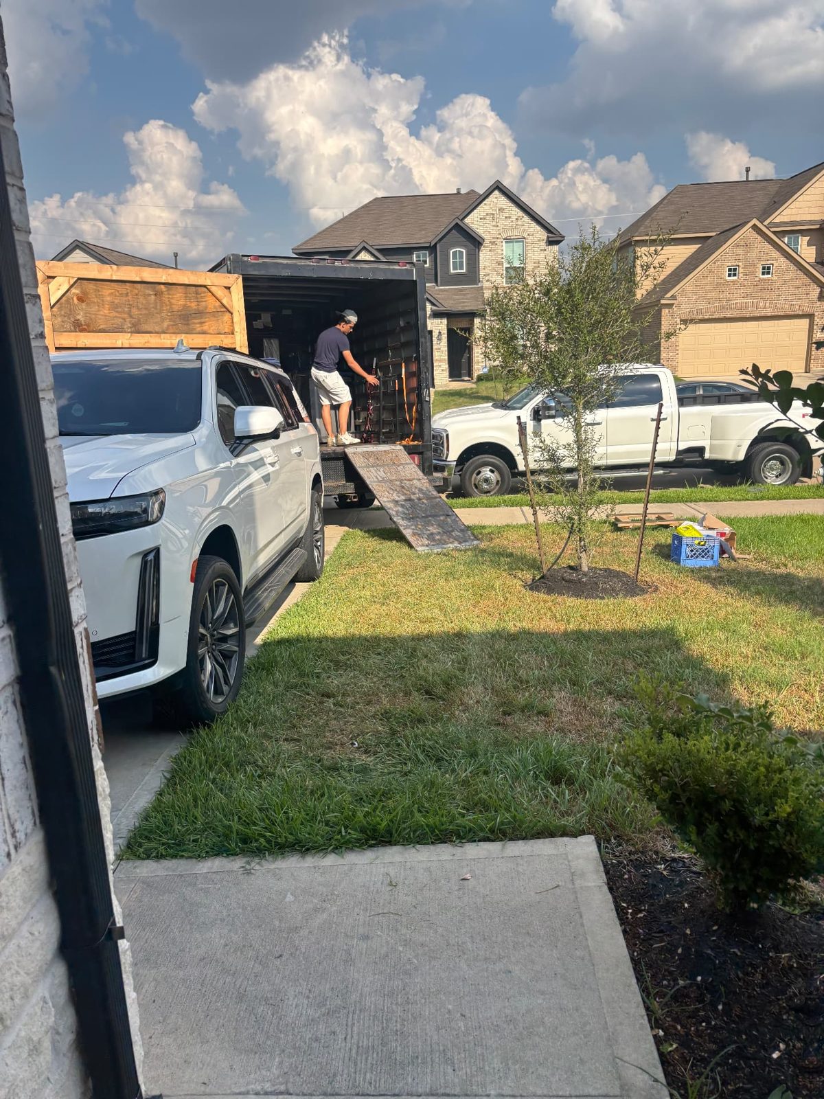 Mover loading a box truck with a ramp in a residential driveway